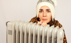 girl sitting in front of room heater